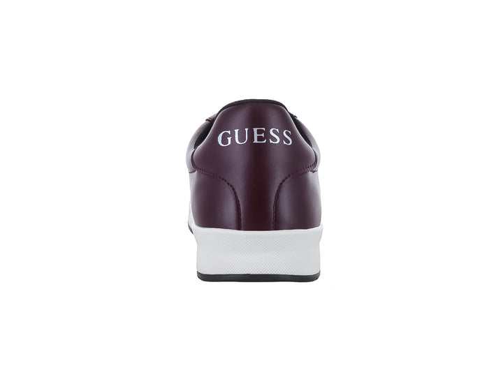 Tenis casuales Guess de color vino con suela blanca y cordones negros.