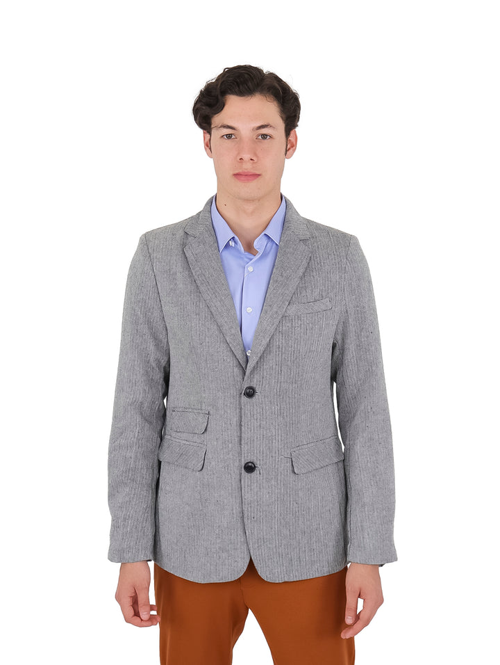 Hombre vistiendo un saco casual de color gris con botones negros.