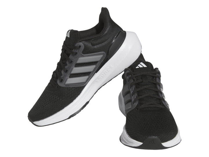 Tenis deportivos Adidas Ultrabounce en color negro con suela blanca y detalles grises para niño.