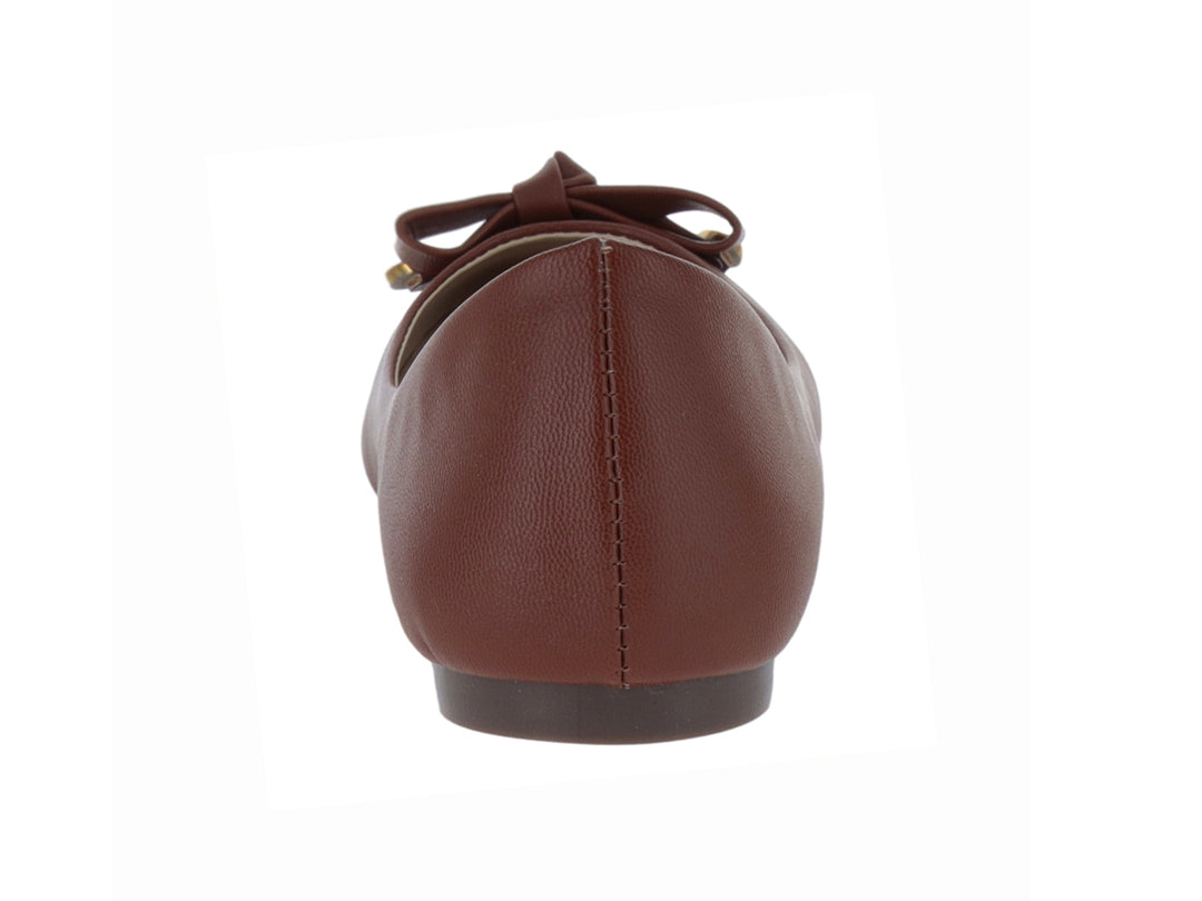 Zapato plano color tan para mujer con detalle de moño y pequeño adorno dorado en la punta.