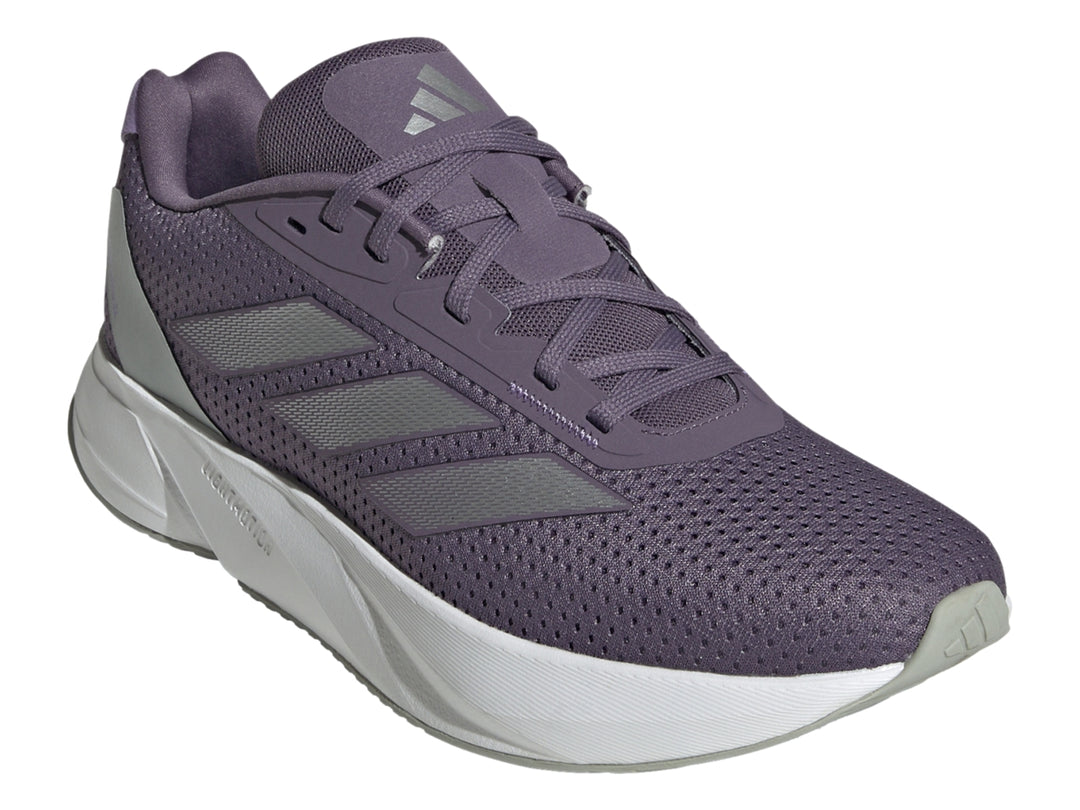 Tenis deportivos Adidas color morado con franjas plateadas y suela blanca.