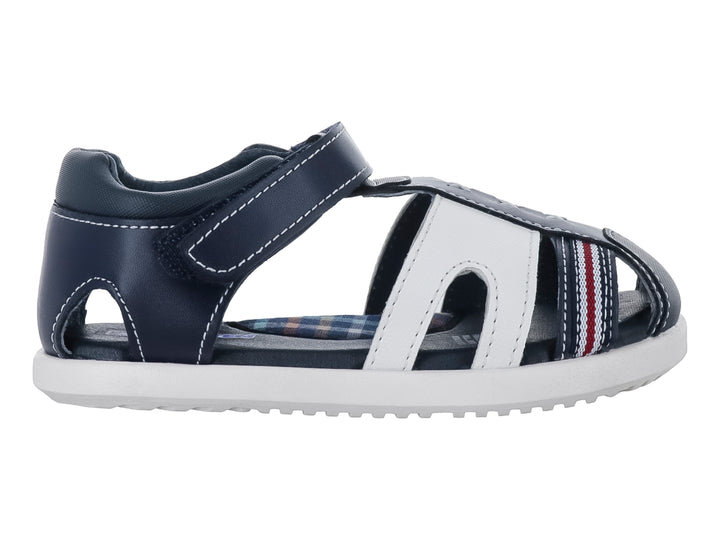 Sandalia infantil Karsten en colores azul marino y blanco con cierre de velcro y detalles en rojo.