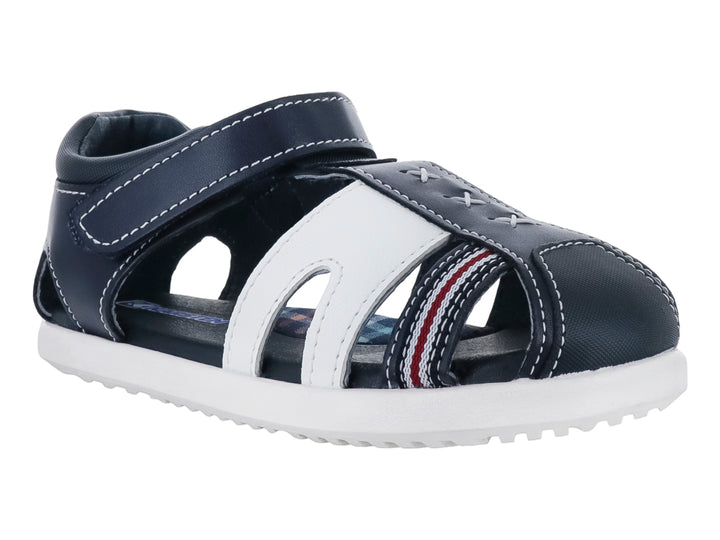 Sandalia infantil Karsten en colores azul marino y blanco con cierre de velcro y detalles en rojo.