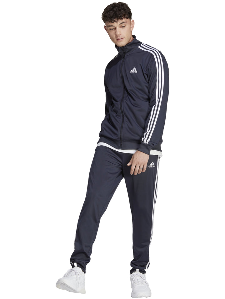 Conjunto deportivo Adidas azul marino con rayas blancas laterales en chaqueta y pantalón.