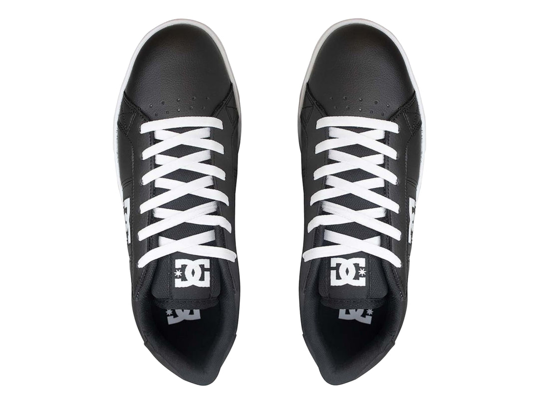Tenis DC Shoes color negro con suela y cordones blancos.