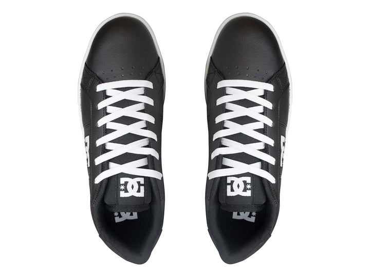 Tenis DC Shoes color negro con suela y cordones blancos.