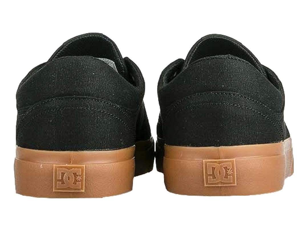Tenis DC Shoes color negro con suela de goma color café y logotipo blanco lateral.
