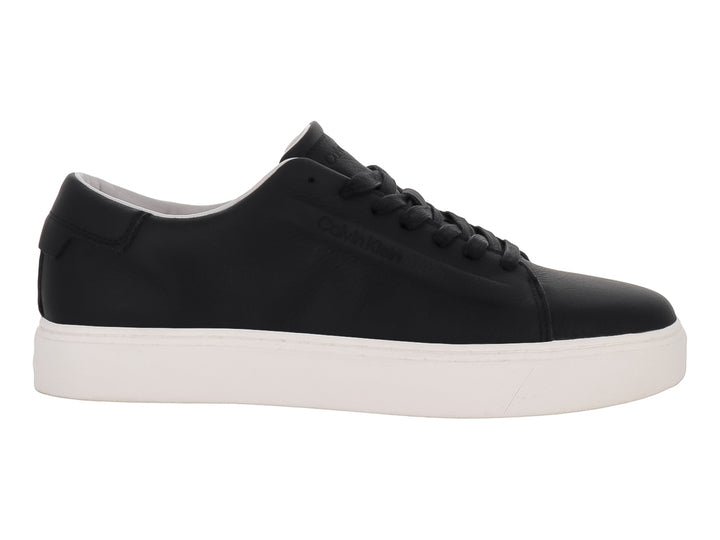 Tenis Calvin Klein de cuero negro con suela blanca y cordones, diseño minimalista y casual.