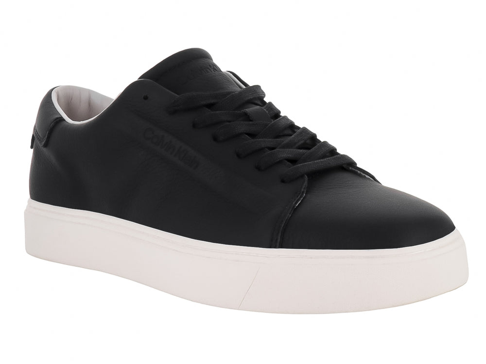 Tenis Calvin Klein de cuero negro con suela blanca y cordones, diseño minimalista y casual.