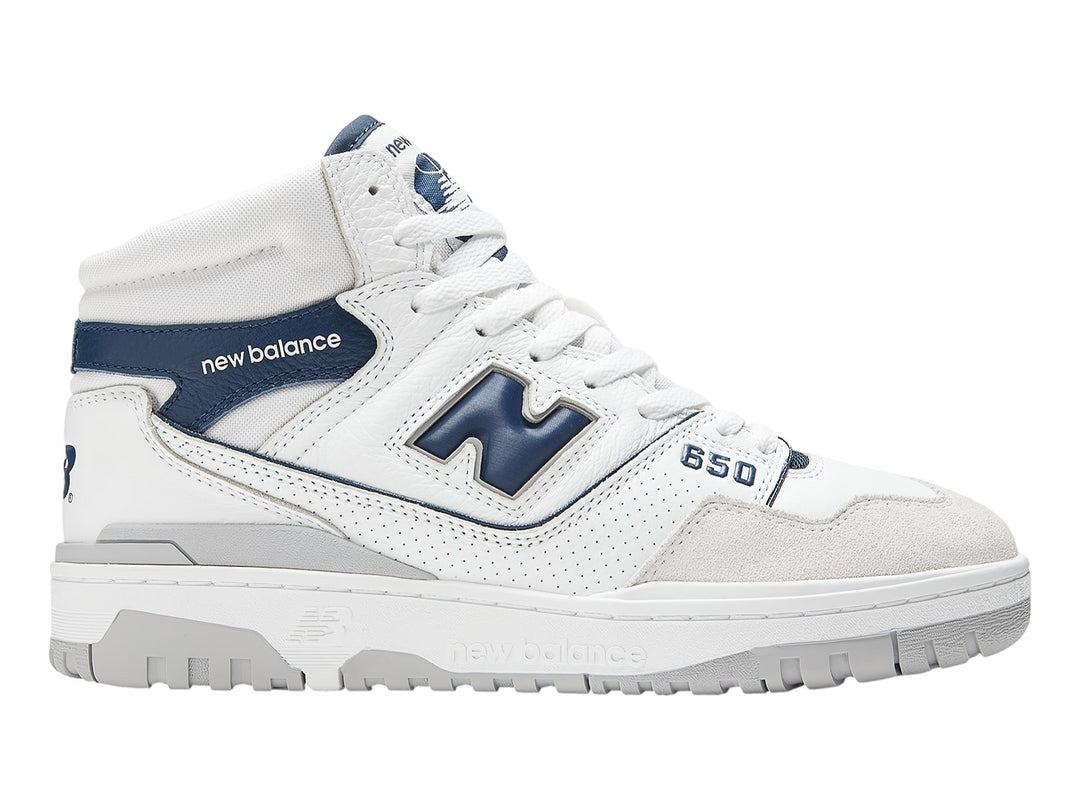 Tenis New Balance BB650 blancos con detalles en azul marino y suela gris.