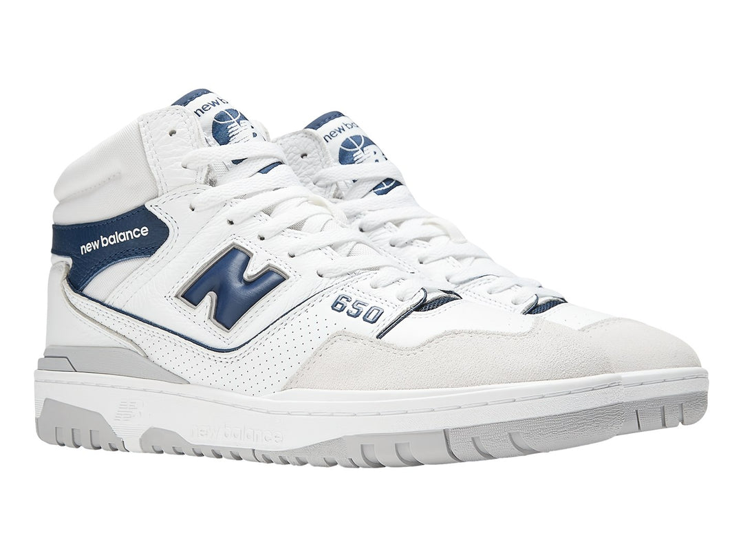 Tenis New Balance BB650 blancos con detalles en azul marino y suela gris.