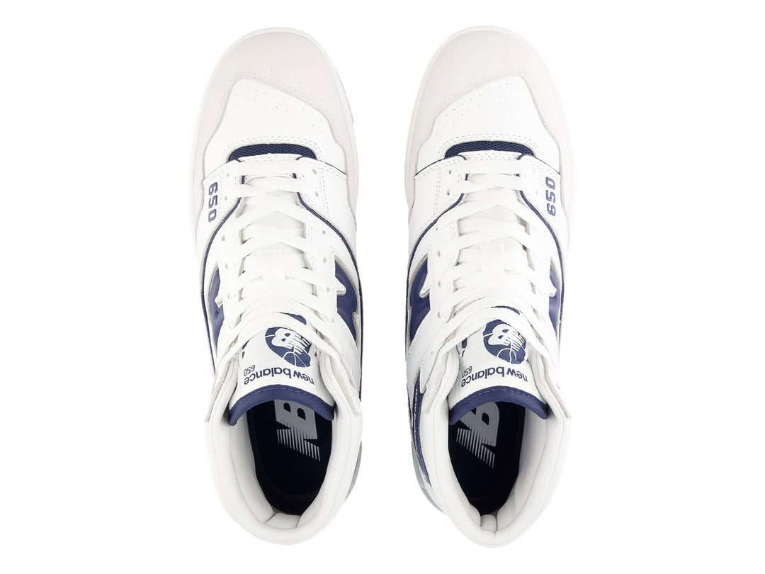 Tenis New Balance BB650 blancos con detalles en azul marino y suela gris.