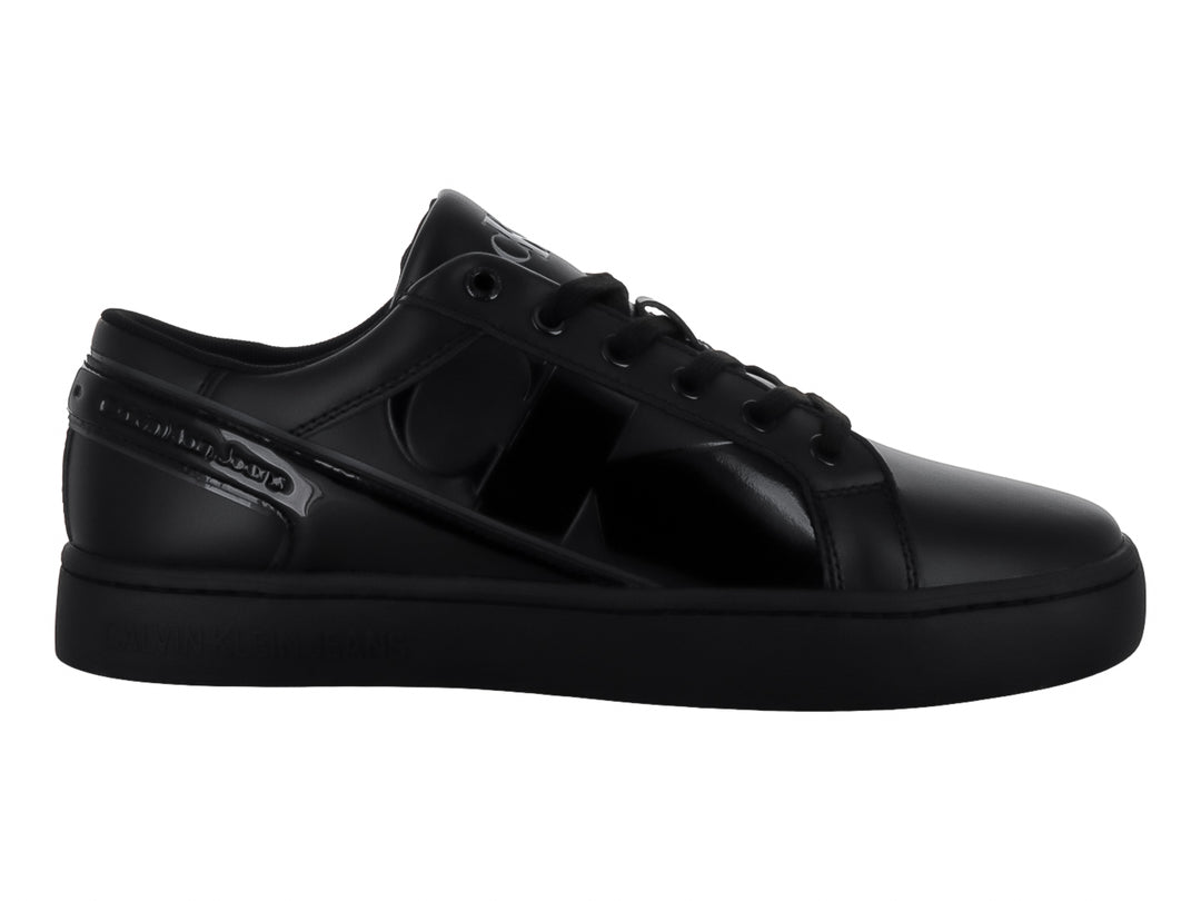 Tenis Calvin Klein negros de corte bajo con detalles brillantes en el lateral y suela plana.