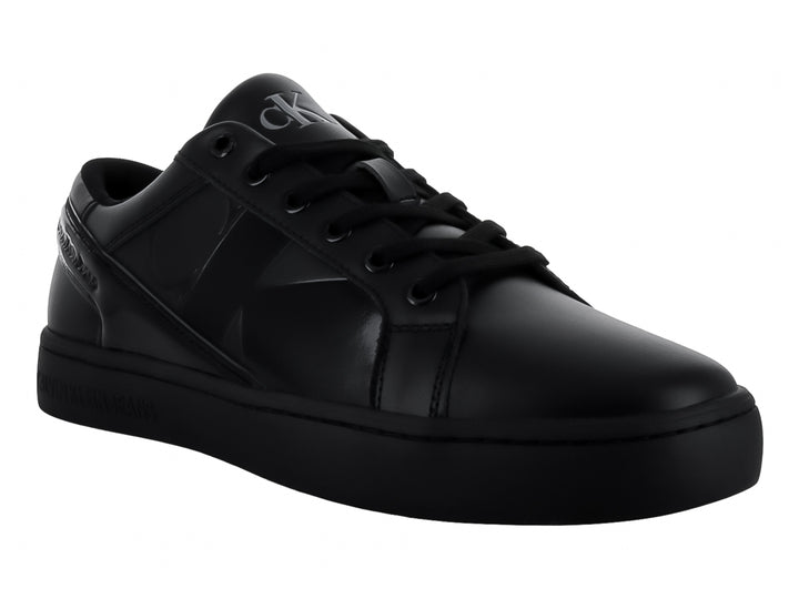 Tenis Calvin Klein negros de corte bajo con detalles brillantes en el lateral y suela plana.