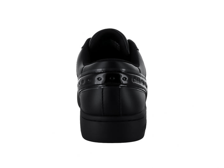 Tenis Calvin Klein negros de corte bajo con detalles brillantes en el lateral y suela plana.