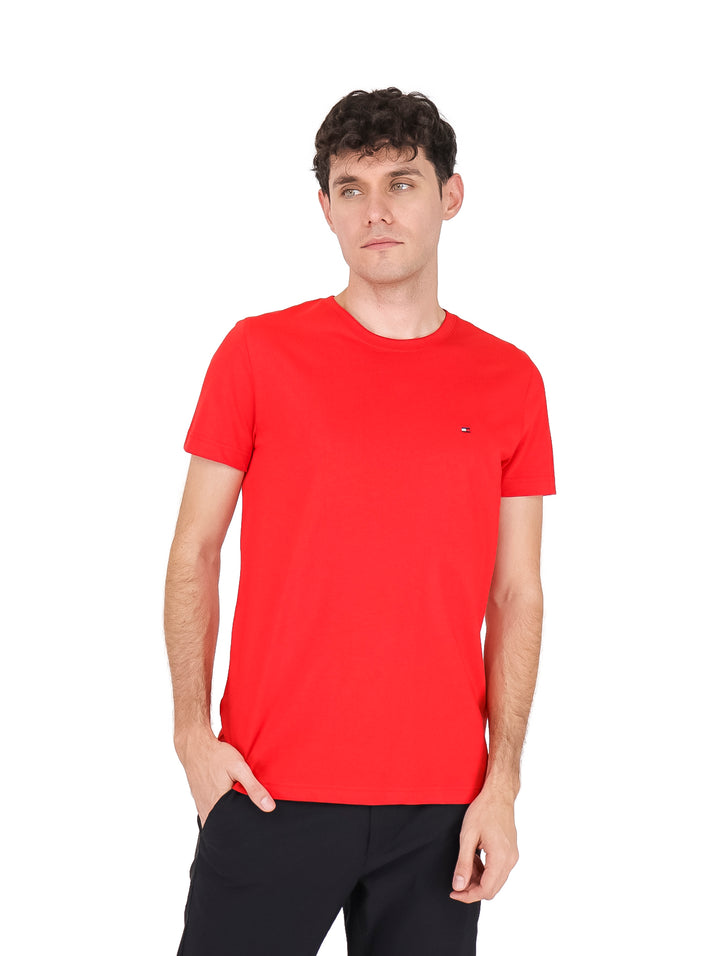 Hombre vistiendo una camiseta roja de manga corta y cuello redondo de Tommy Hilfiger.