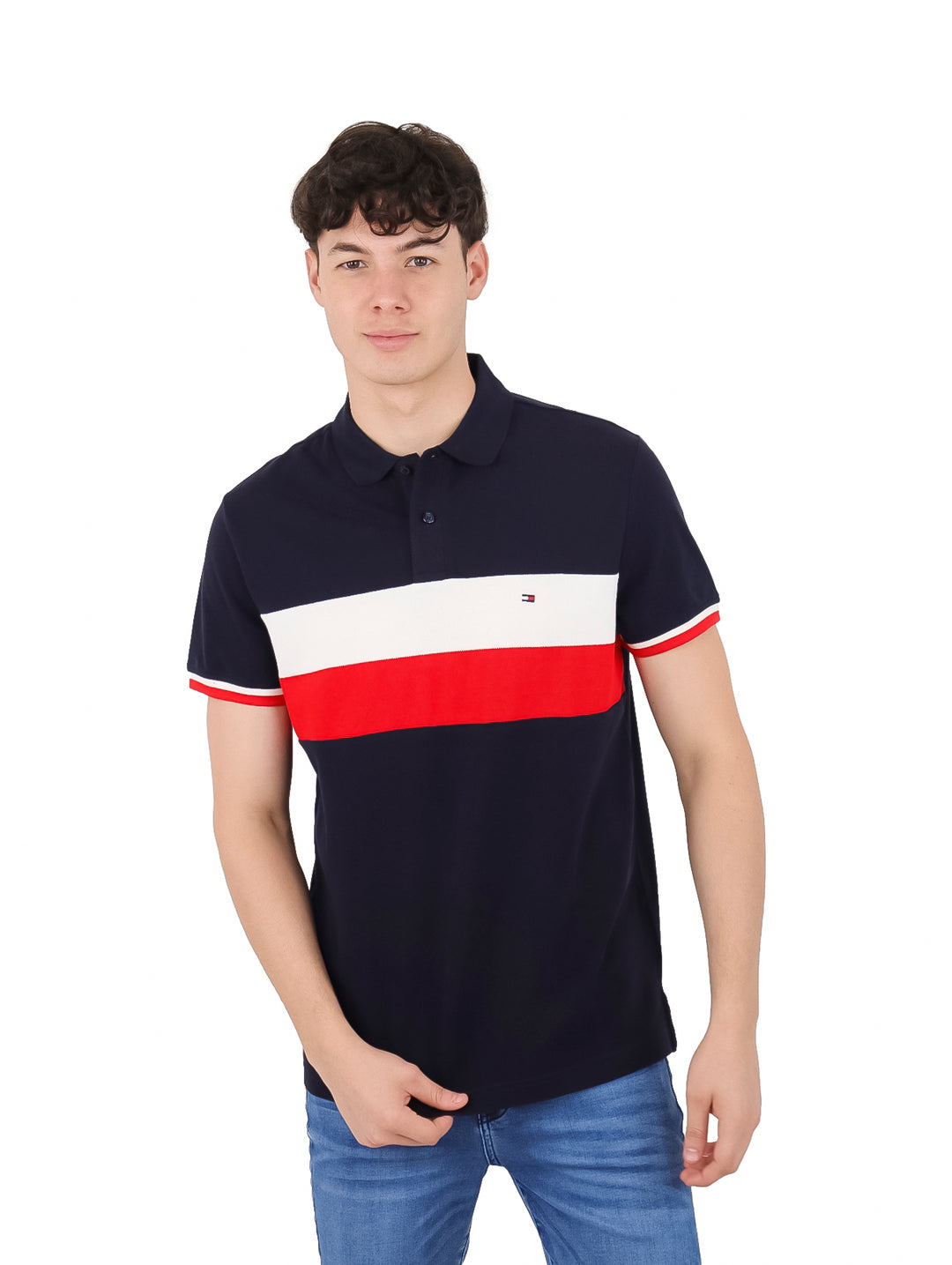 Hombre vistiendo polo azul marino con franjas horizontales blanca y roja en el pecho.