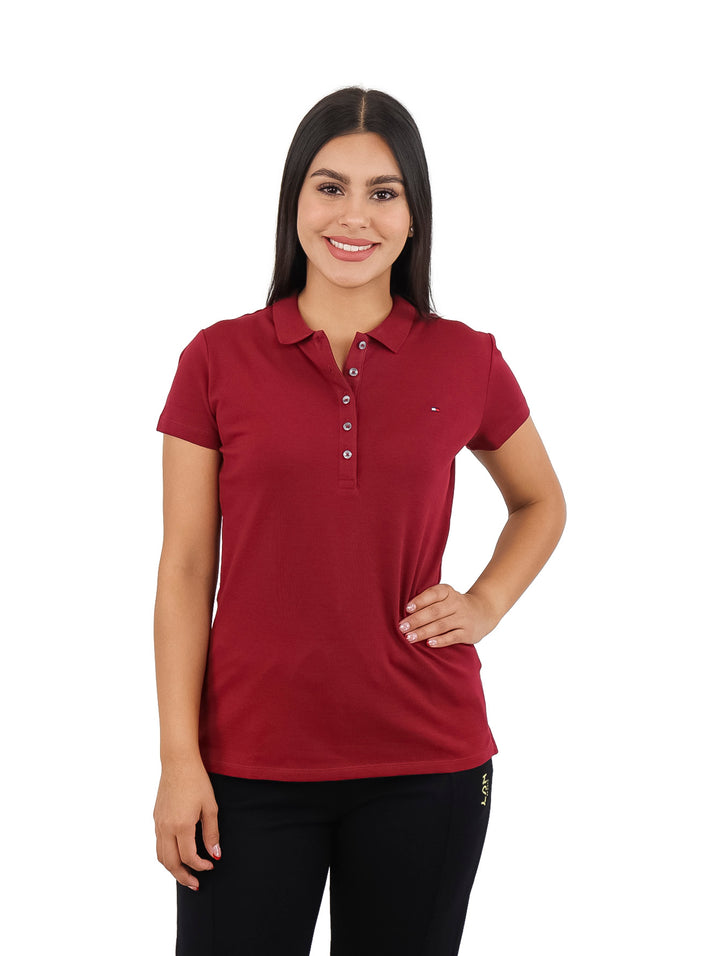 Mujer vistiendo una playera polo de color rojo oscuro con cuello y botones.