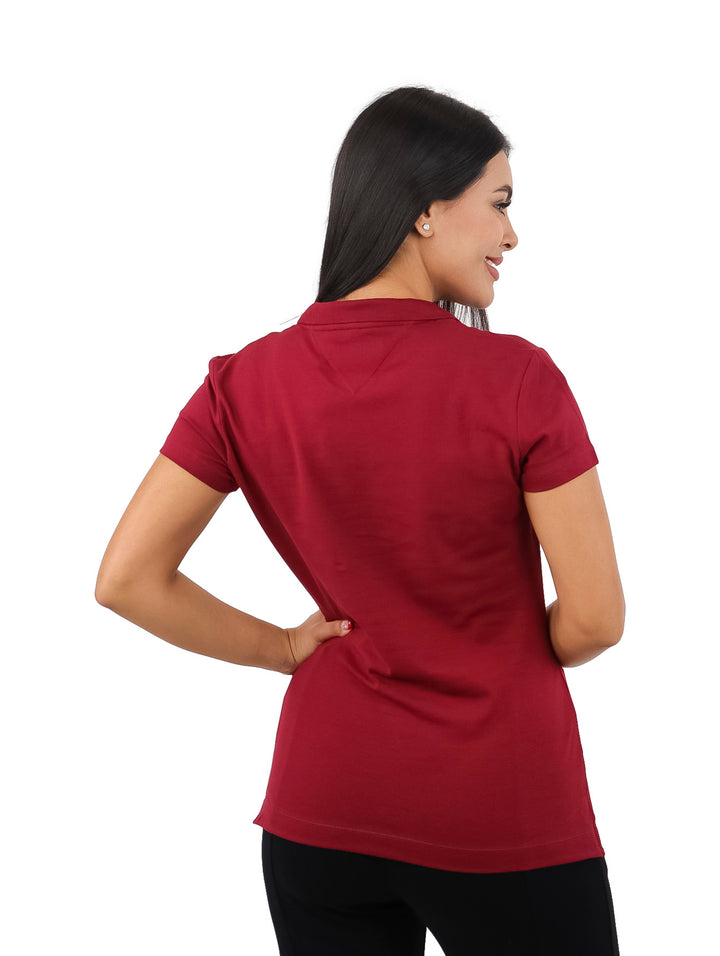 Mujer vistiendo una playera polo de color rojo oscuro con cuello y botones.
