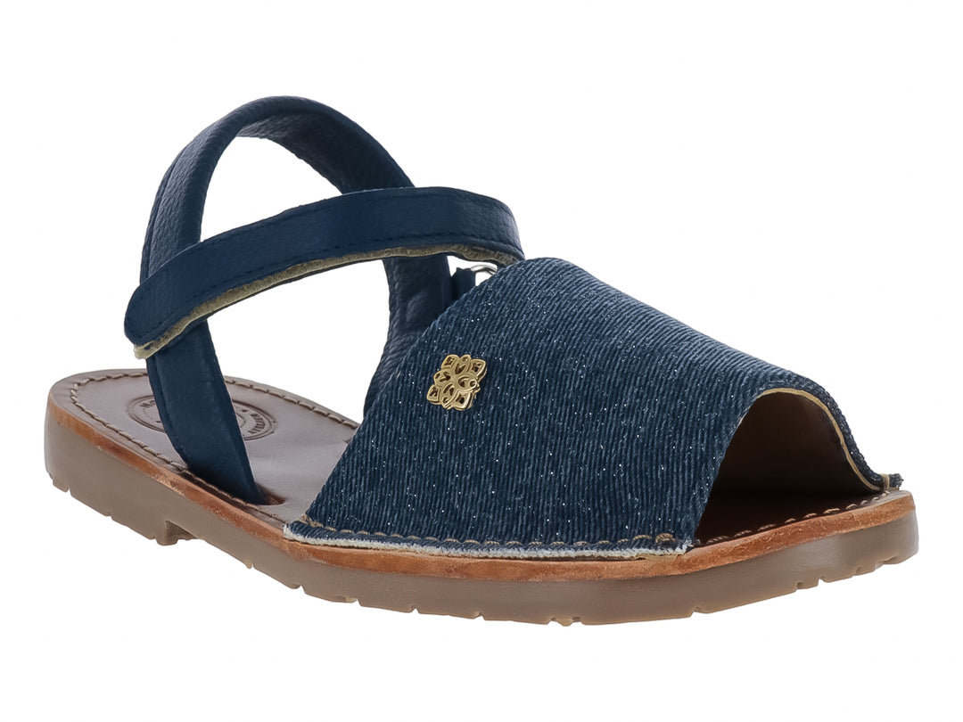 Sandalia azul denim para niña con correas cruzadas y detalle decorativo dorado en la parte frontal.