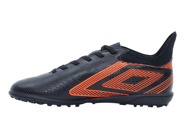 Zapato de fútbol Umbro negro con diseño geométrico naranja y suela para césped sintético.