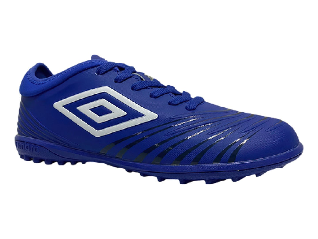 Zapato de fútbol Umbro color azul rey con logo blanco y suela para césped sintético.