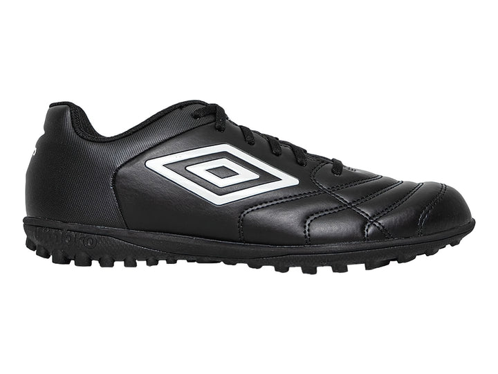 Zapato de fútbol Umbro color negro con logo blanco y suela para césped sintético.