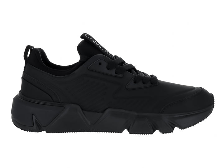 Tenis Calvin Klein color negro total, corte bajo con suela gruesa y cordones.