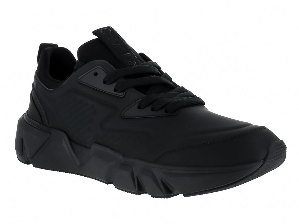 Tenis Calvin Klein color negro total, corte bajo con suela gruesa y cordones.