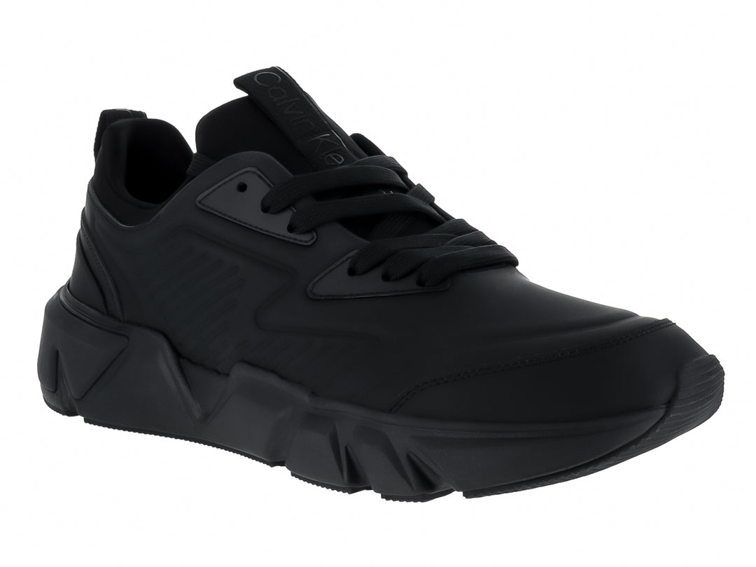 Tenis Calvin Klein color negro total, corte bajo con suela gruesa y cordones.