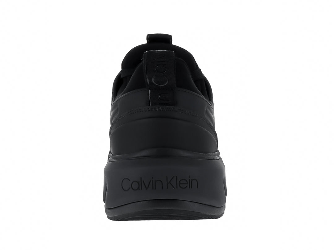 Tenis Calvin Klein color negro total, corte bajo con suela gruesa y cordones.