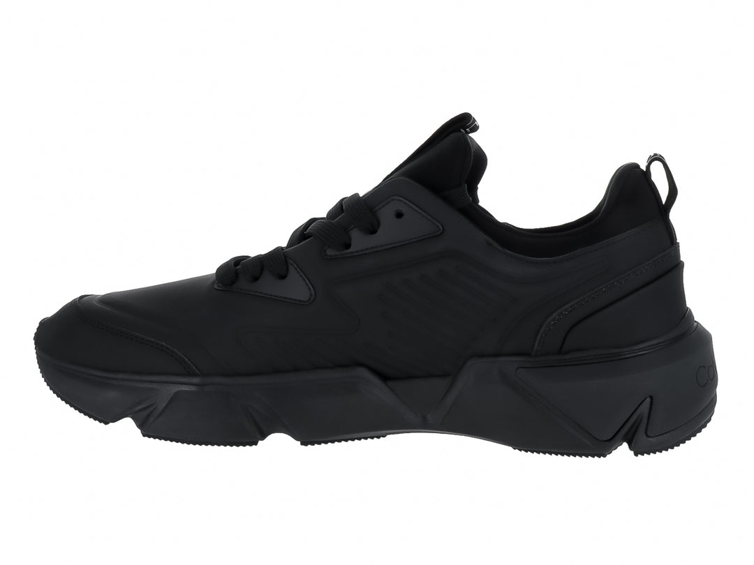 Tenis Calvin Klein color negro total, corte bajo con suela gruesa y cordones.