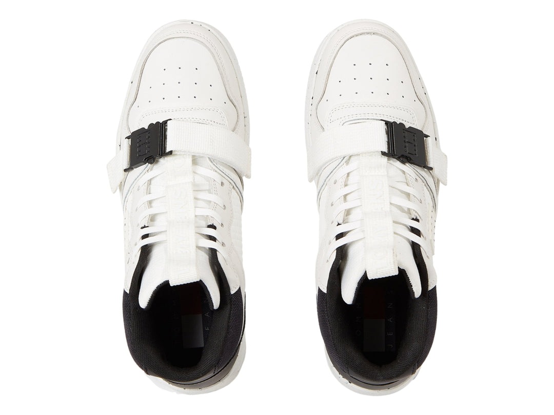 Tenis Tommy Hilfiger color blanco y negro con correa de hebilla y suela blanca moteada.