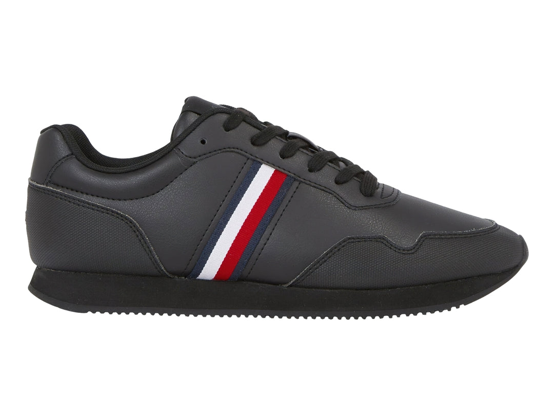 Tenis deportivos color negro con franja lateral tricolor en rojo, blanco y azul.