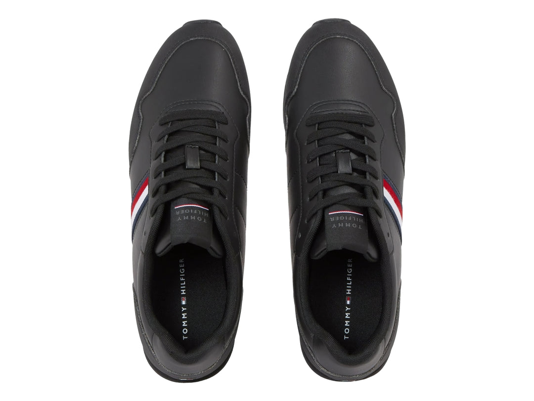 Tenis deportivos color negro con franja lateral tricolor en rojo, blanco y azul.