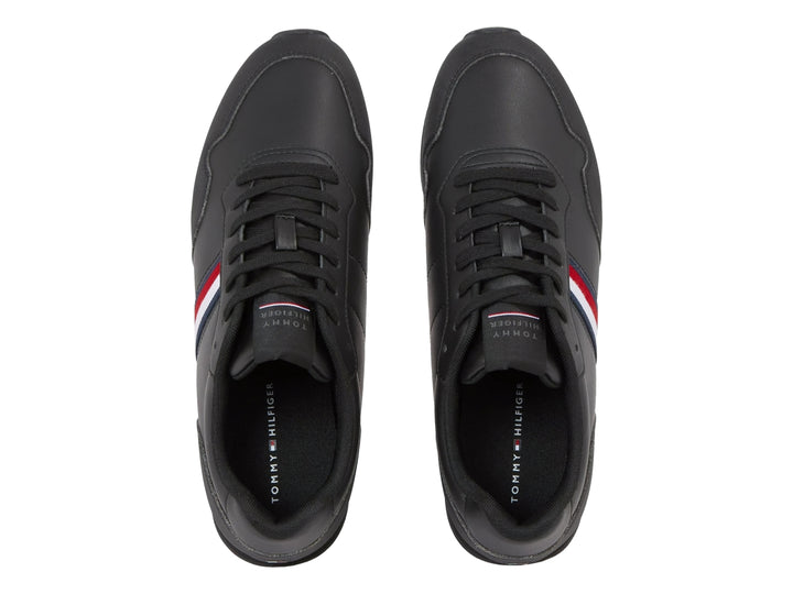 Tenis deportivos color negro con franja lateral tricolor en rojo, blanco y azul.