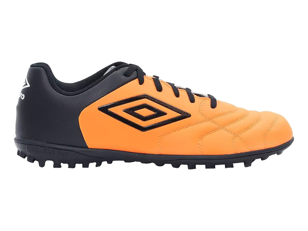 Zapato de fútbol Umbro color naranja y negro con suela para césped sintético.