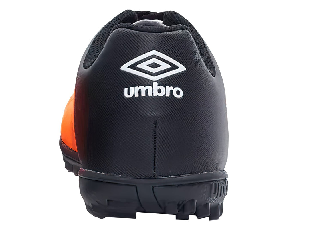 Zapato de fútbol Umbro color naranja y negro con suela para césped sintético.