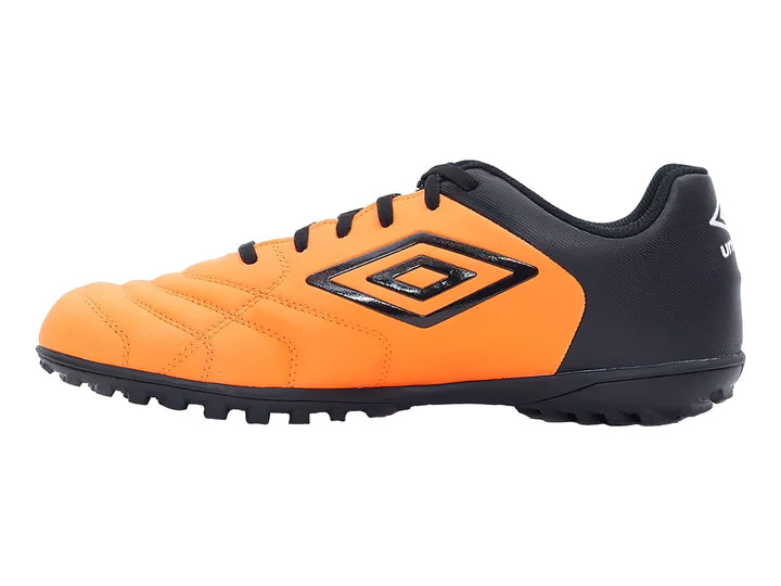 Zapato de fútbol Umbro color naranja y negro con suela para césped sintético.