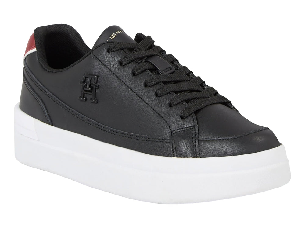 Tenis Tommy Hilfiger color negro con suela blanca ancha y detalle rojo en el talón.