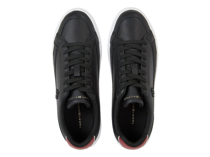 Tenis Tommy Hilfiger color negro con suela blanca ancha y detalle rojo en el talón.
