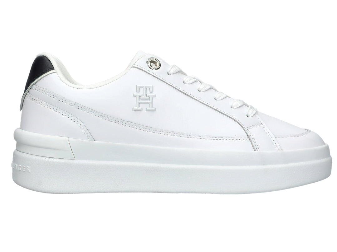 Tenis Tommy Hilfiger color blanco con suela elevada y detalle negro en el talón.