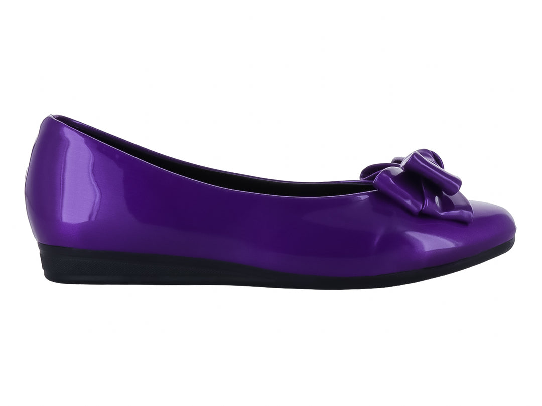 Zapato plano color morado brillante con un moño decorativo en la parte frontal y suela negra.