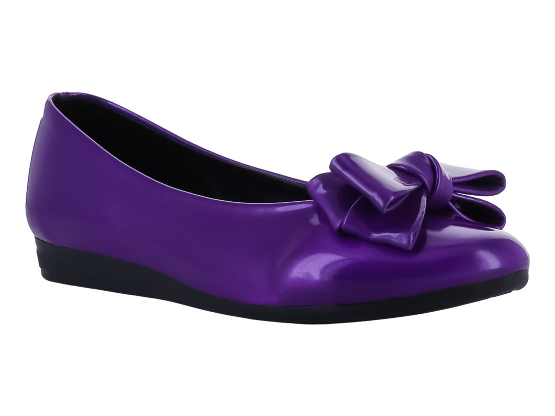 Zapato plano color morado brillante con un moño decorativo en la parte frontal y suela negra.