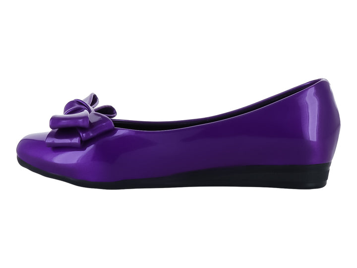 Zapato plano color morado brillante con un moño decorativo en la parte frontal y suela negra.