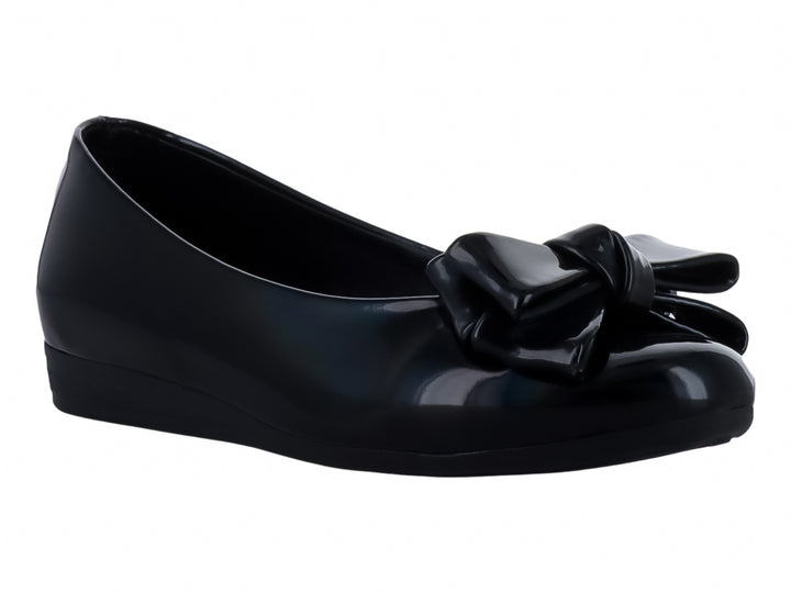 Zapato plano color negro brillante para niña con detalle de moño en la parte frontal.