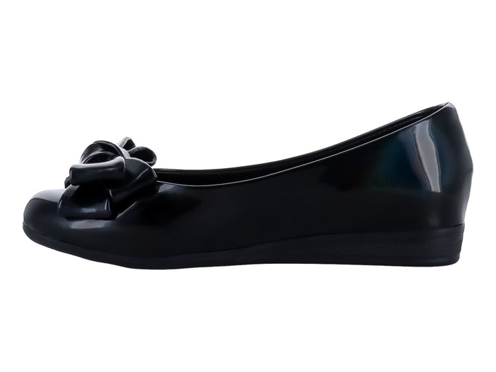 Zapato plano color negro brillante para niña con detalle de moño en la parte frontal.