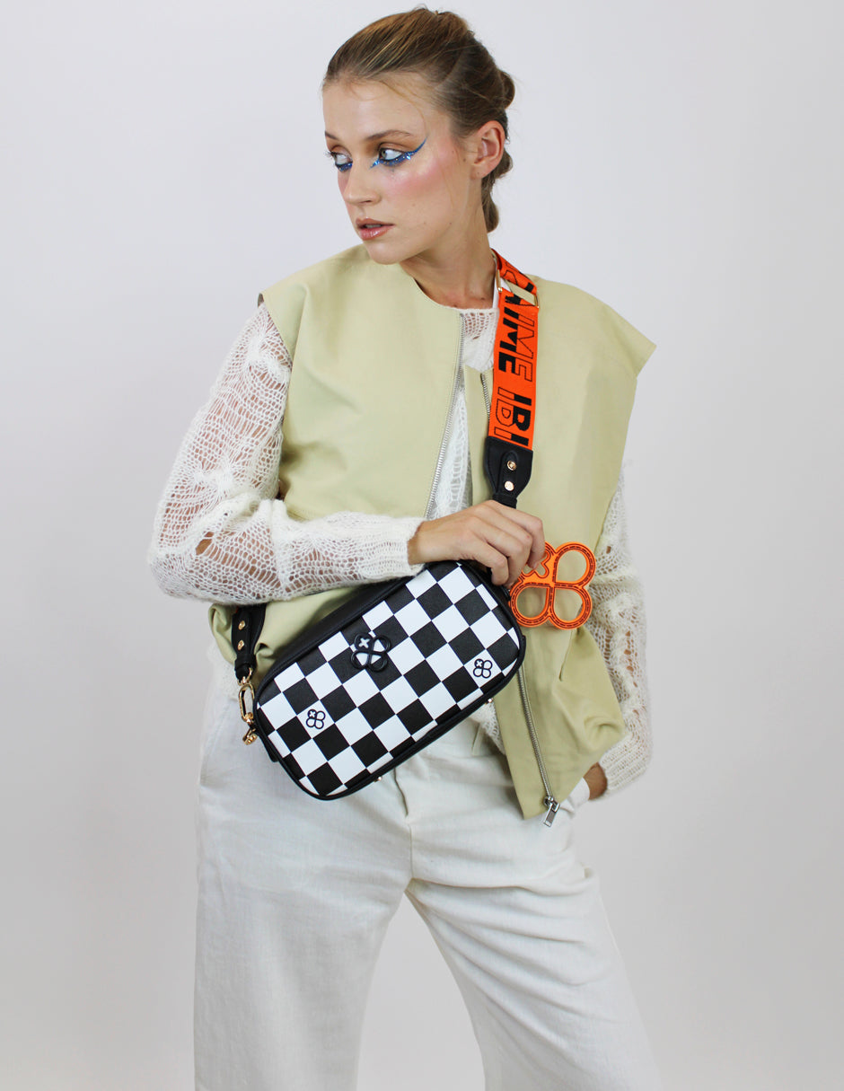 Bolso pequeño Jaime Ibiza con estampado de cuadros blancos y negros y detalles en dorado.
