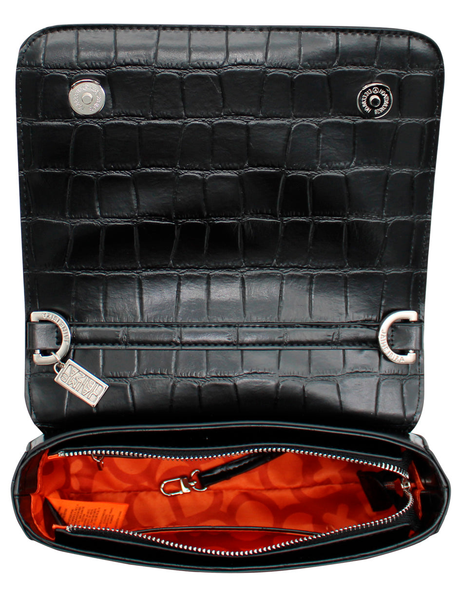 Bolso de hombro negro con textura de cocodrilo, correa ancha tejida y detalle metálico en forma de cruz.