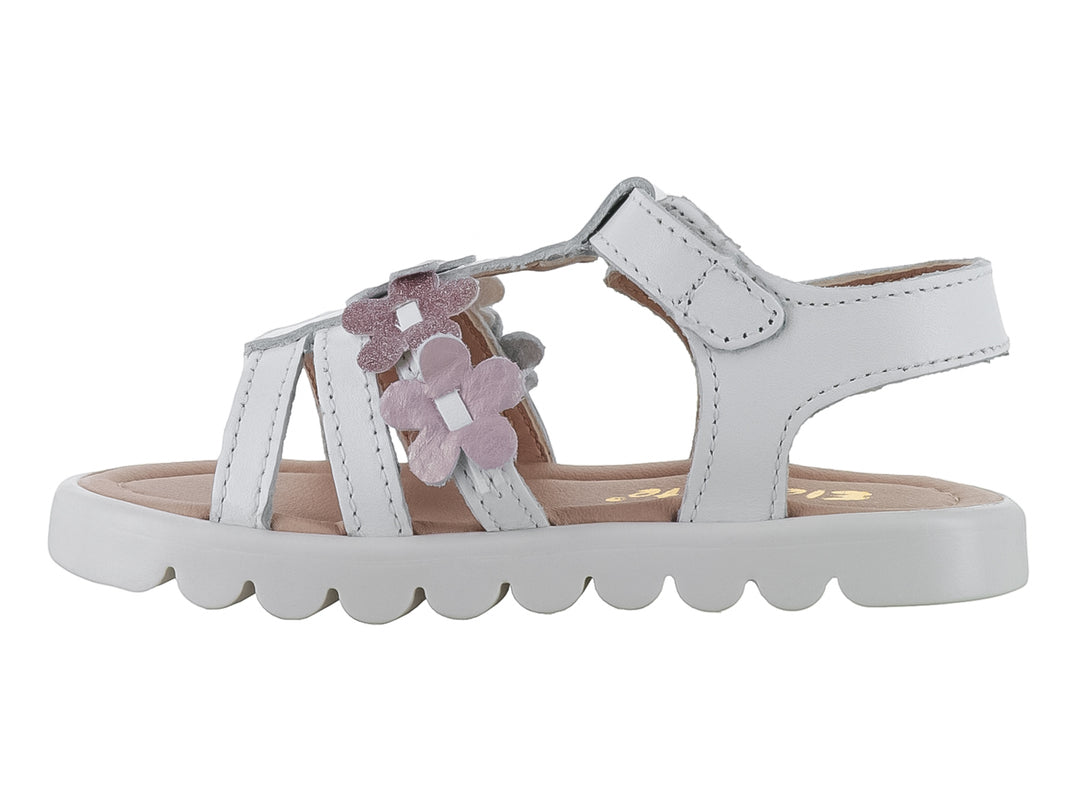 Sandalia blanca para niña con flores rosas brillantes y suela blanca ondulada.